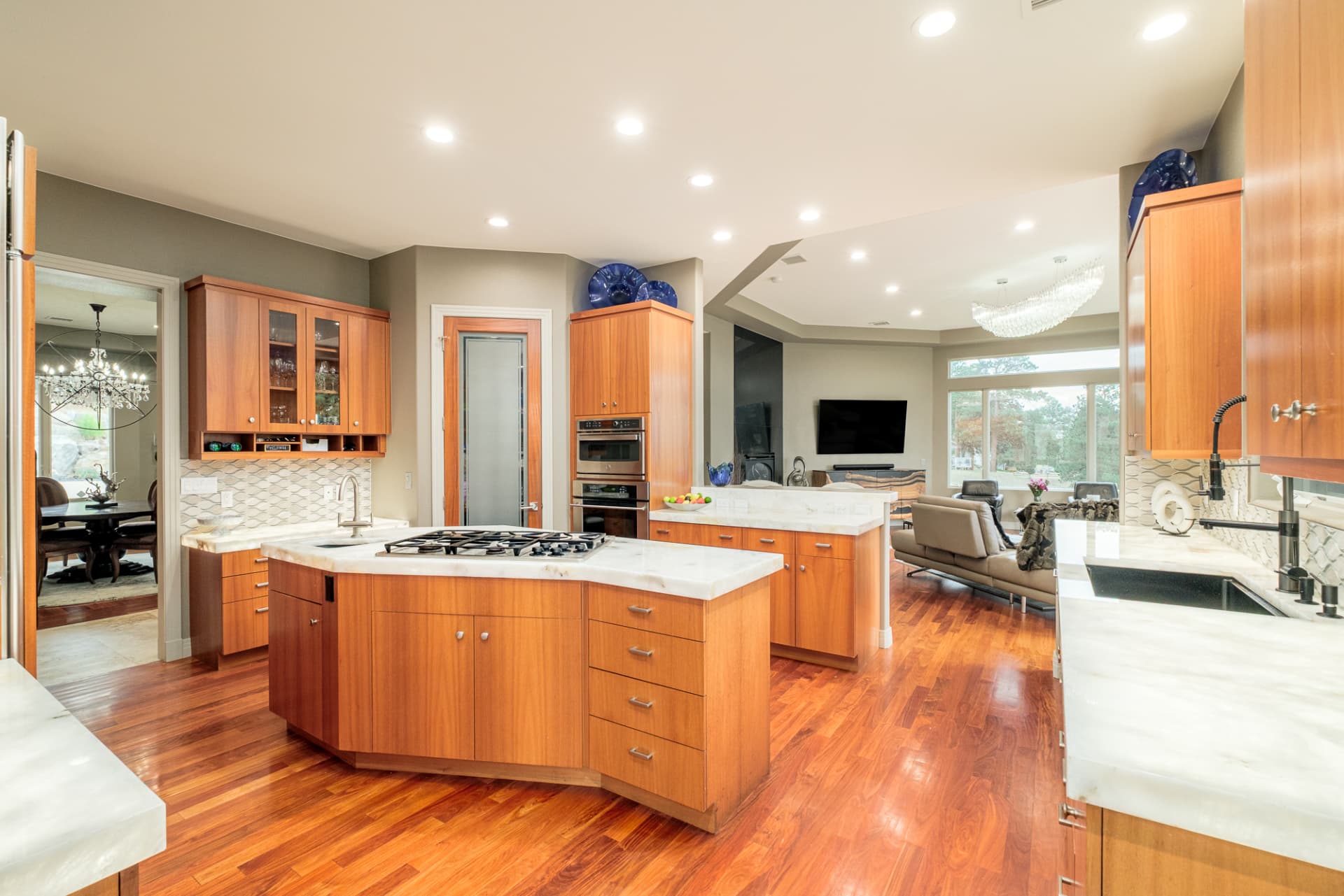 Chef's kitchen with waterfall island and light wood cabinetry