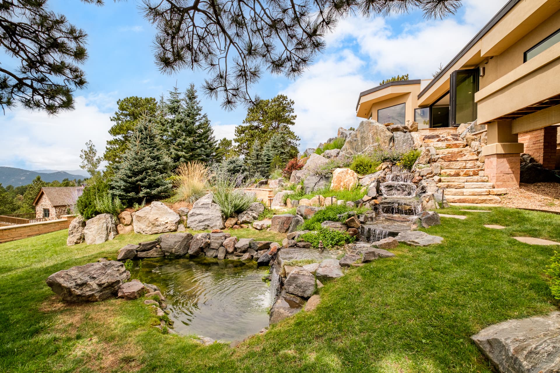 Tiered stone waterfall and pond in the landscaped hillside
