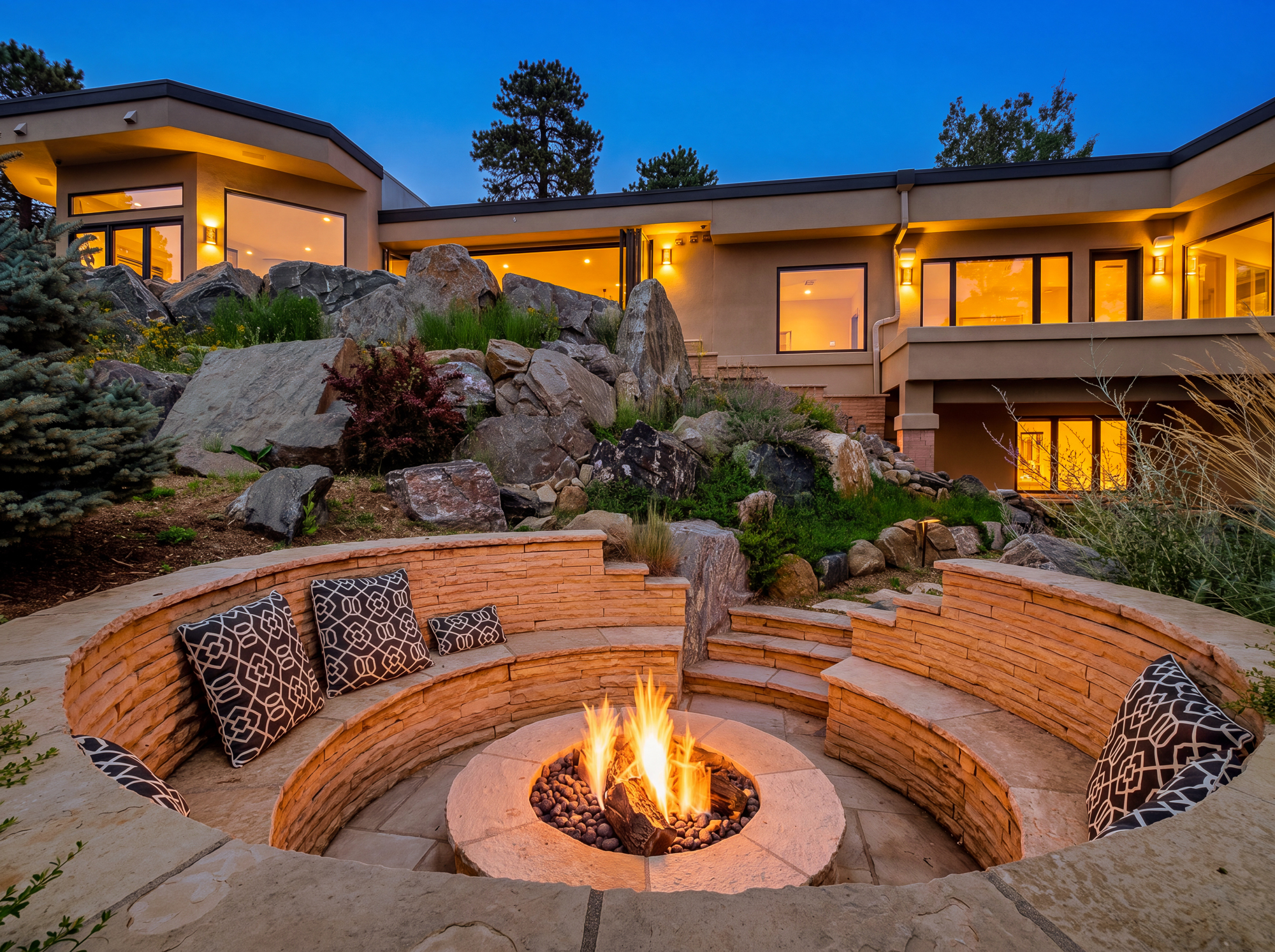 Fire pit at dusk with the house glowing behind