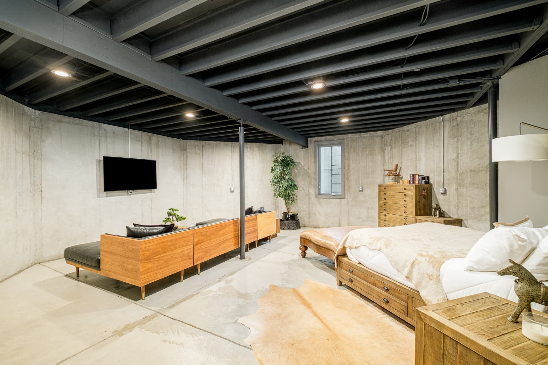 Guest bedroom with exposed joists and concrete walls