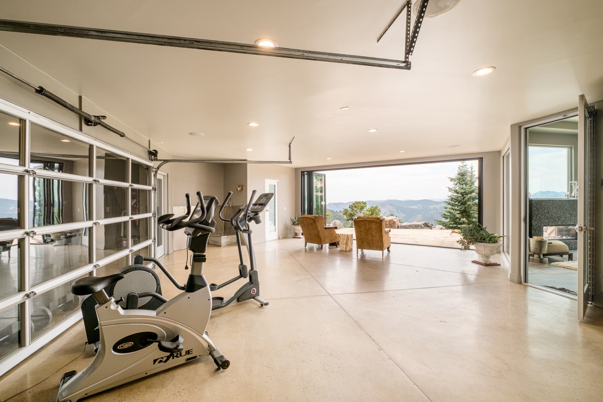 Home gym with glass walls open to the vista