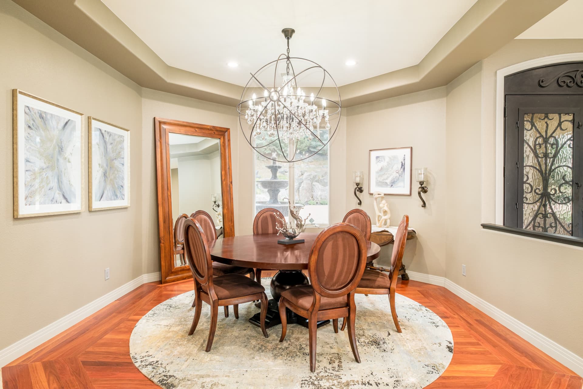 Round dining table beneath a geometric chandelier